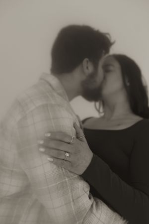 A romantic sequence showing a couple kissing while displaying an engagement ring.