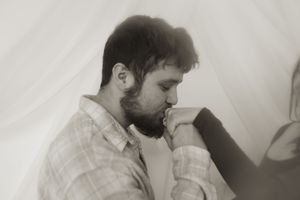Two people sharing an intimate moment against a light background.