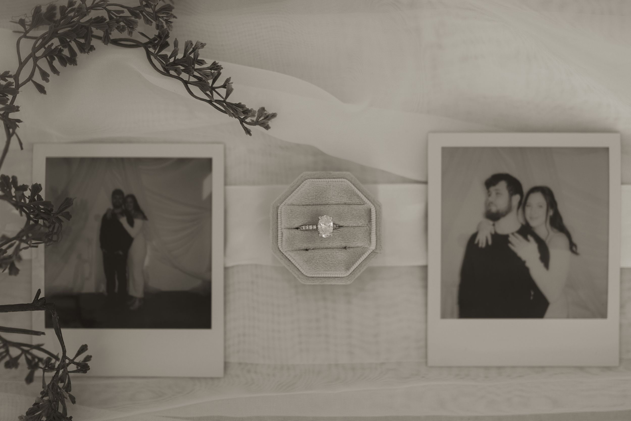 Black and white artistic wall display with decorative frames and floral elements.