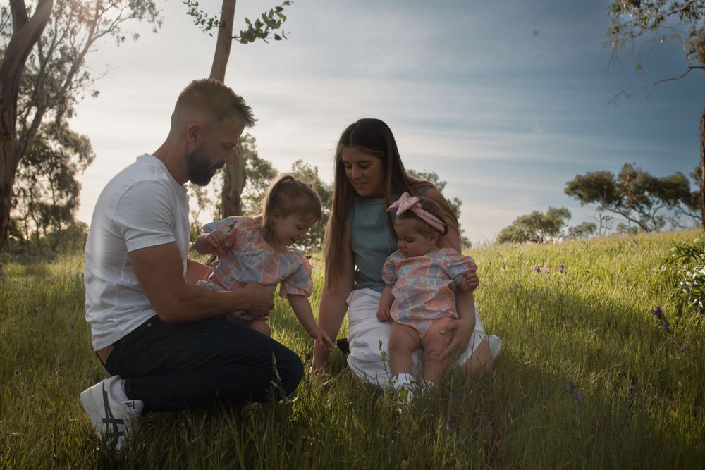 Family enjoying a sunny afternoon together in a grassy field.