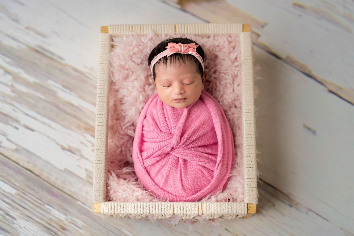 Newborn baby girl wrapped in pink