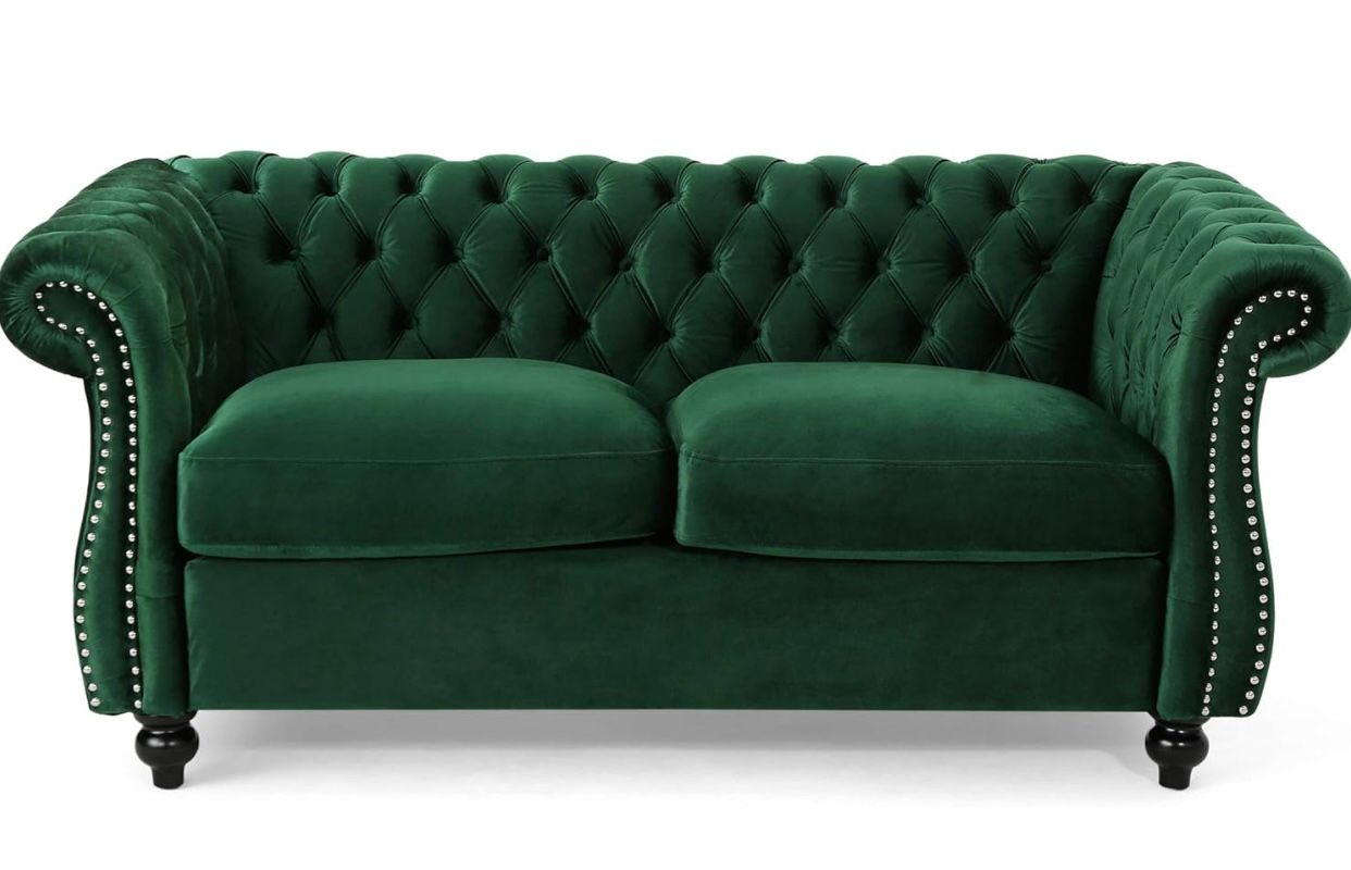 Luxurious emerald green tufted Chesterfield sofa with rolled arms and nail head trim.