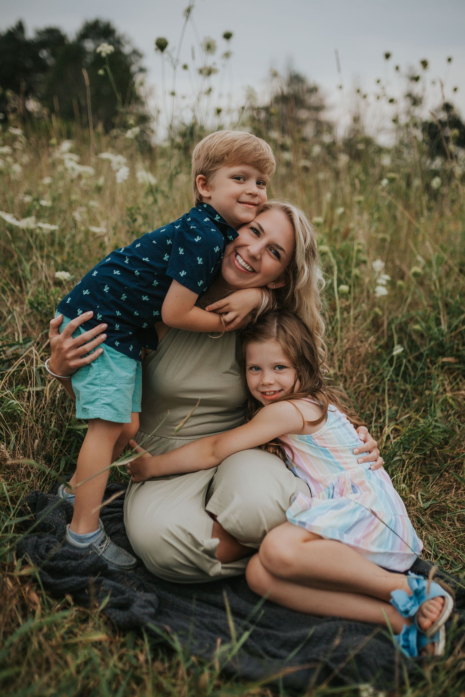 Loving family moment captured in a wildflower field at sunset with casual summer outfits.