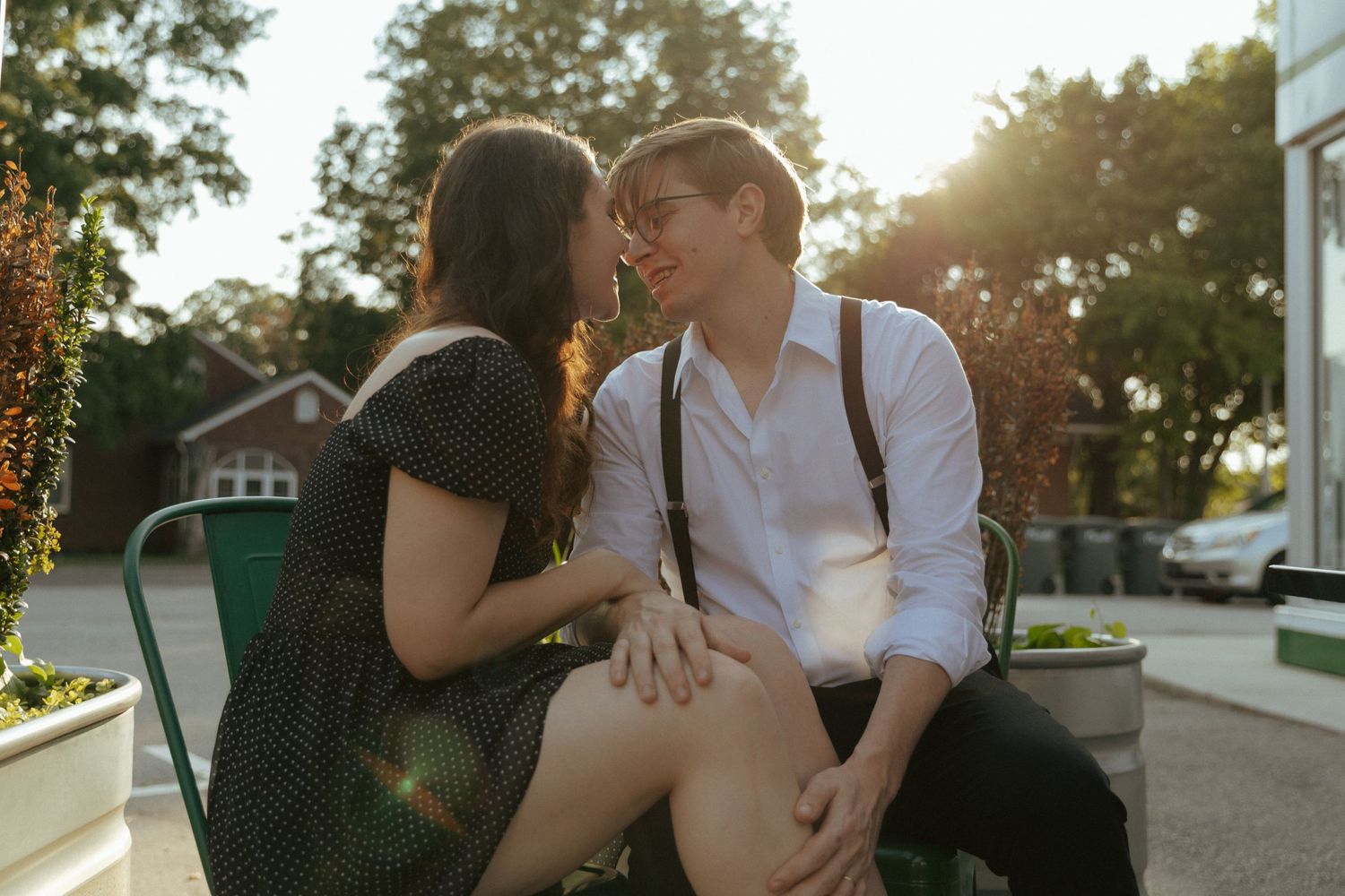 A romantic couple sharing an intimate moment at sunset while sitting outdoors.