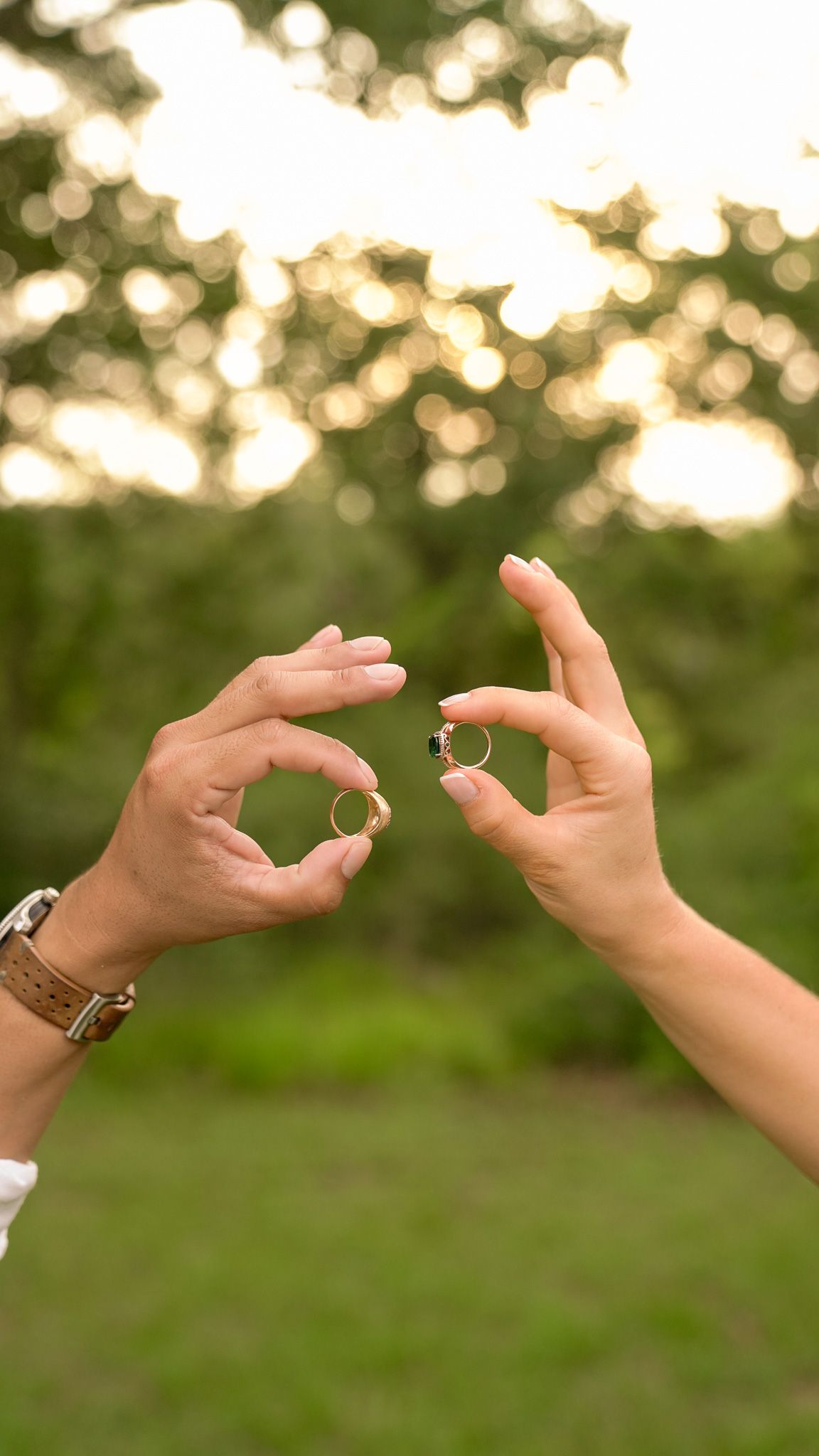 Wedding party celebrates by throwing their hands up in joy outdoors.