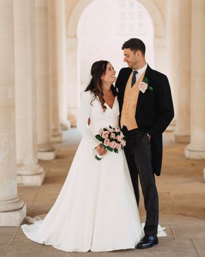 Wedding couple share intimate moment under classical colonnade with white pillars at  Inner Temple in Central London.