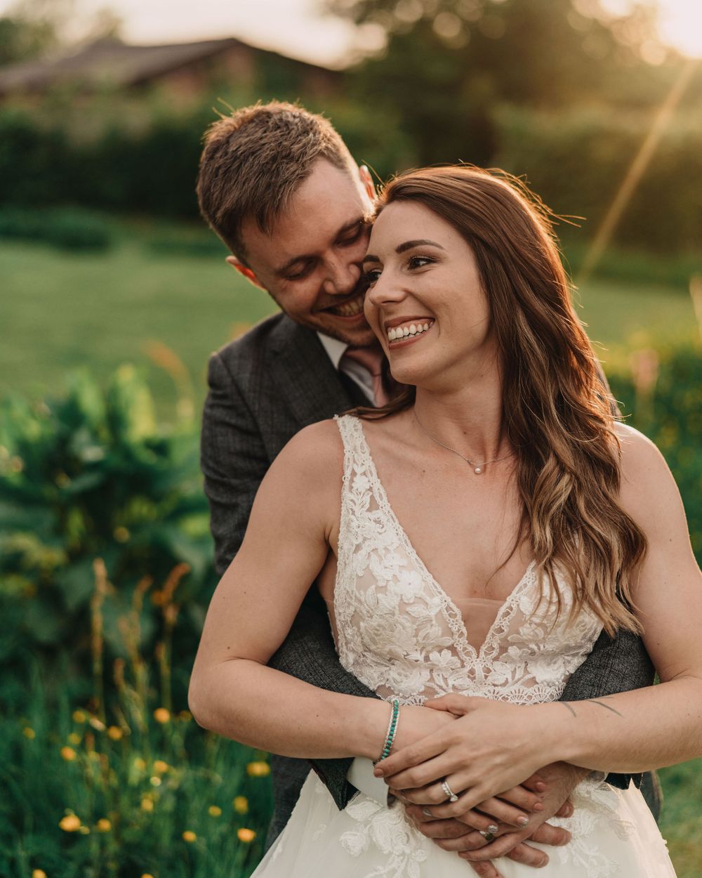 A romantic sunset portrait of a couple embracing in a garden setting.