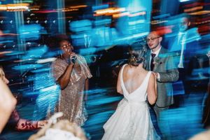 Wedding reception dance floor with motion blur and blue lighting effects creates energetic party atmosphere.