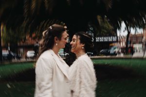 Intimate moment captured between couple in white winter wedding attire outdoors at Hackney Town Hall.
