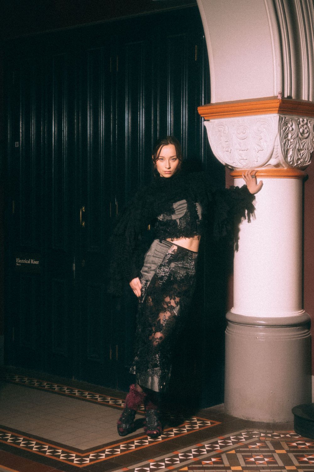 Artistic detail shot of lace clothing and burgundy accessories in low light.