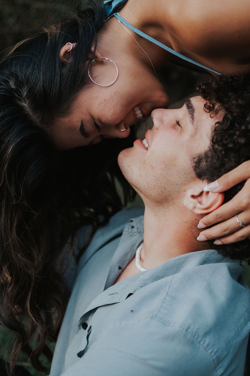 Close-up romantic couple sharing intimate moments in soft lighting and blue tones.