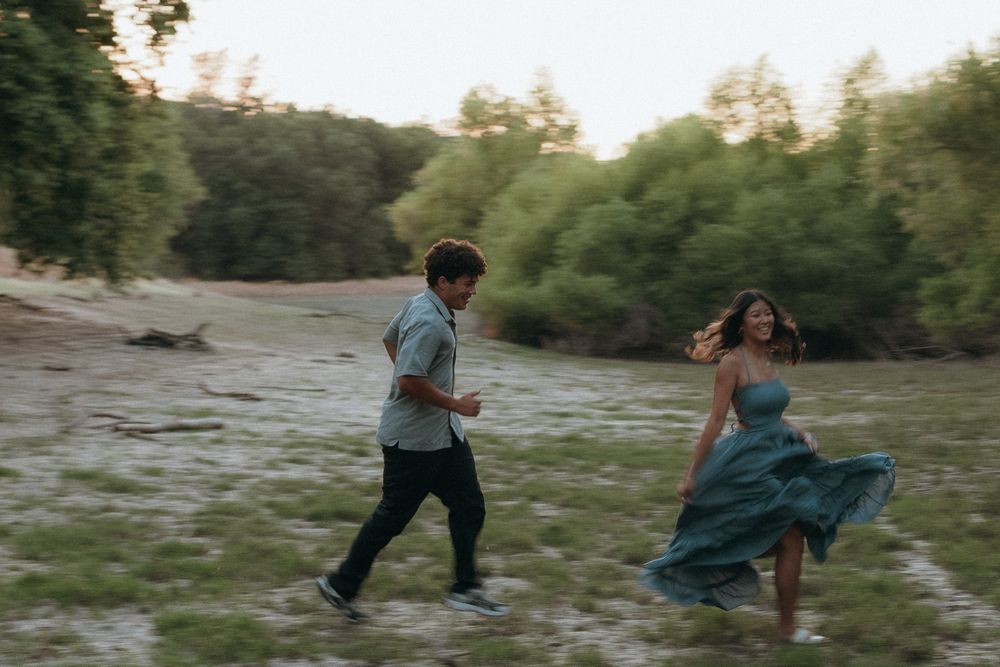 Sequence of silhouettes playing and running along a scenic riverbank at sunset.