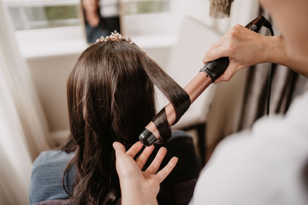 Hair styling preparation with professional tools and techniques.