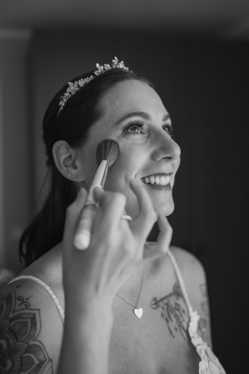 Makeup application during wedding preparation with delicate tiara detail.