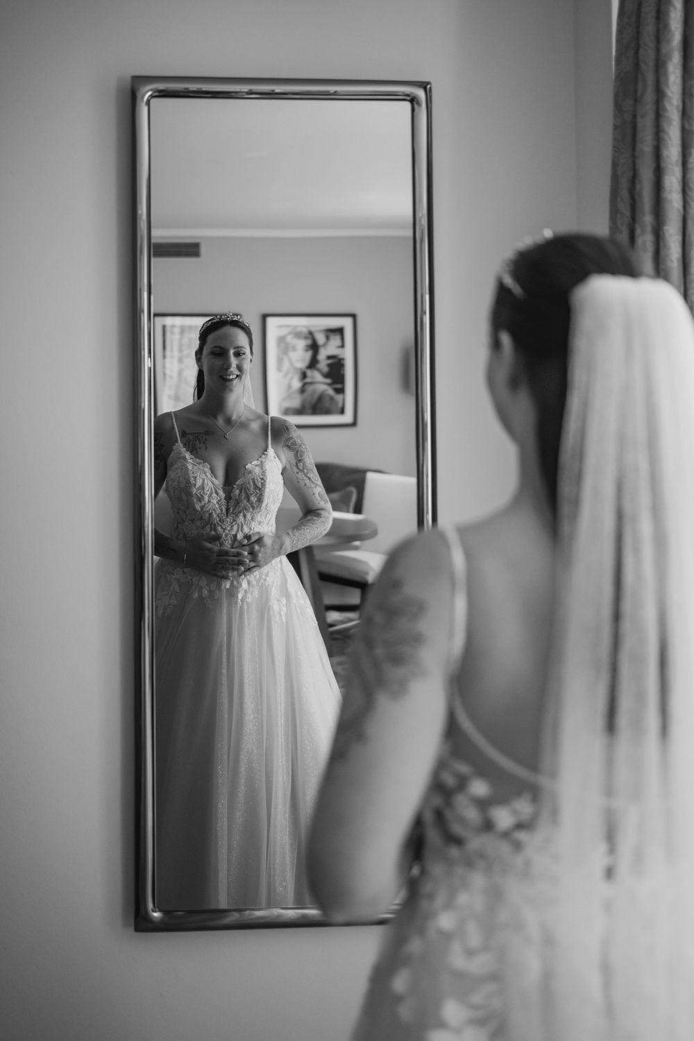 Mirror reflection capturing bridal portrait in elegant white wedding gown.