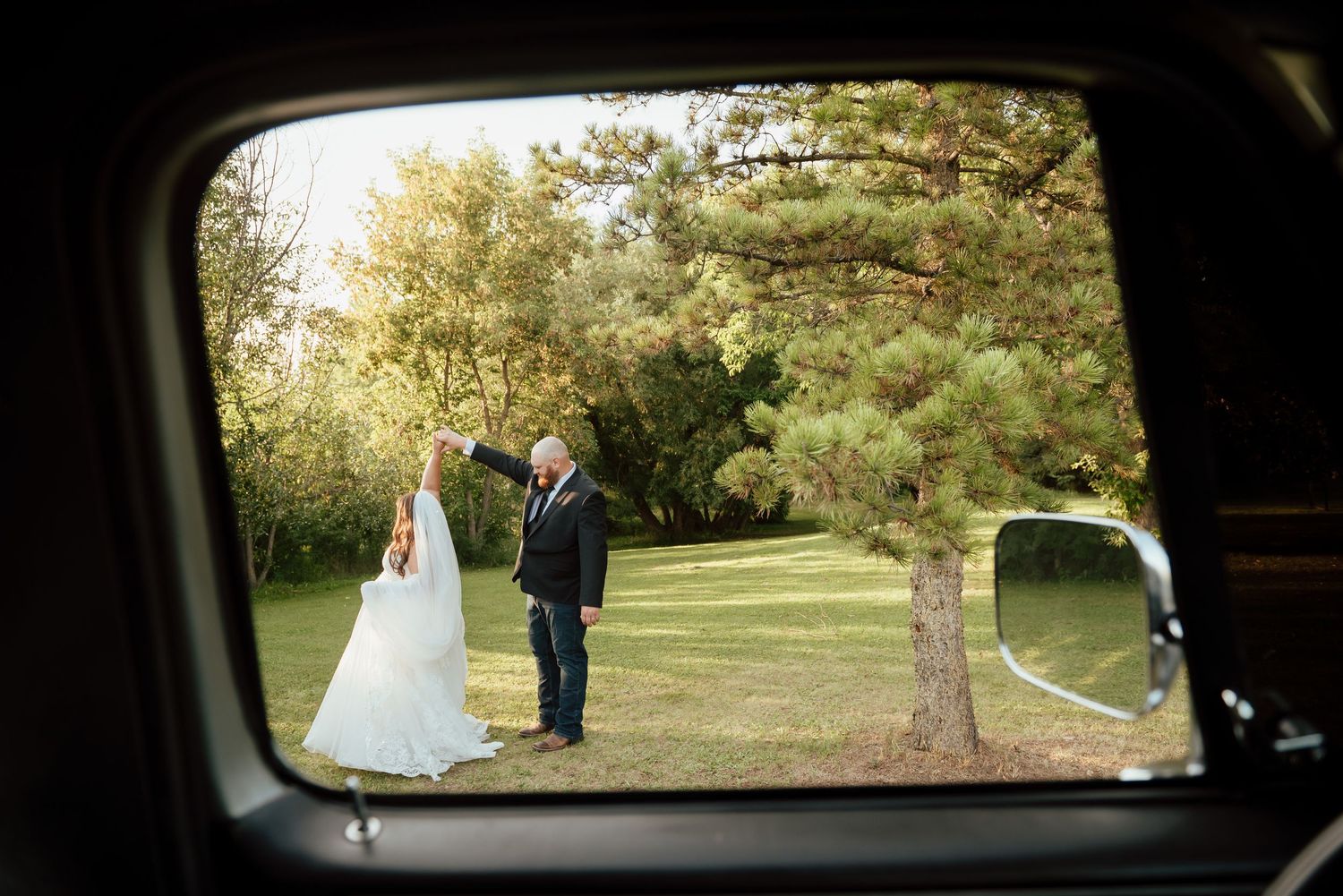 A couple shares a romantic moment in an autumn meadow with majestic Rocky Mountains and golden trees in the background.