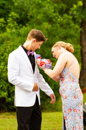 Couple sharing a candid moment in formal wear at an outdoor event.