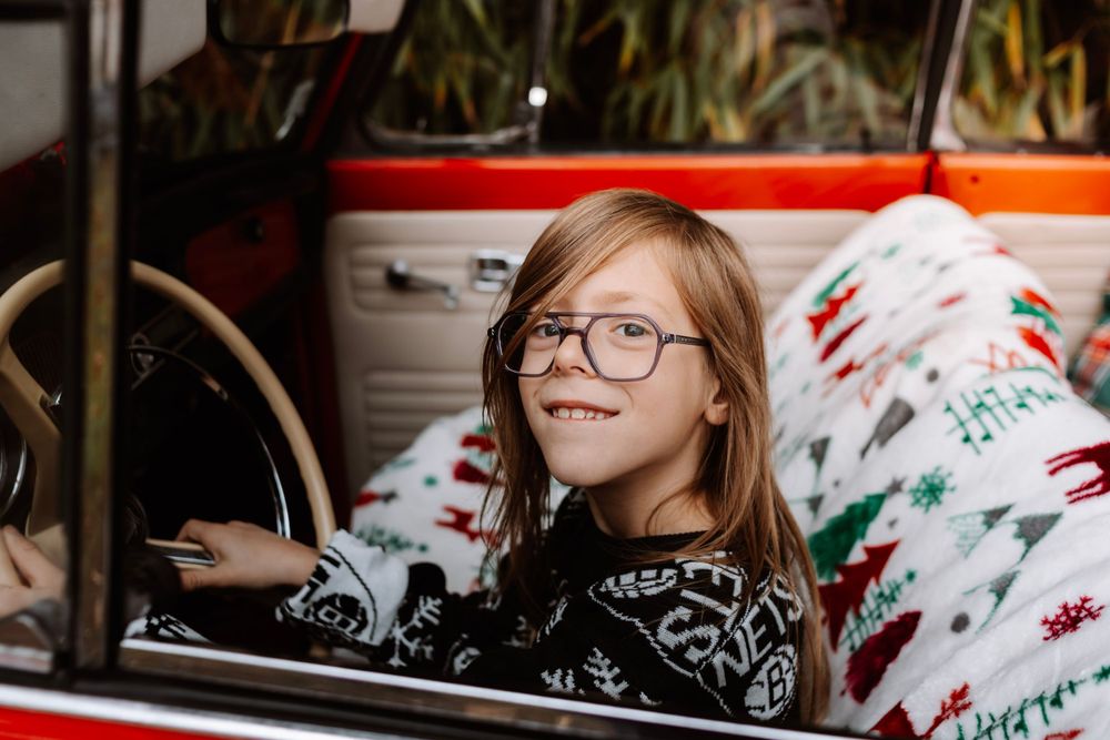 Mini-session photo de Noël 2024 avec une coccinelle VW rouge décorée pour les fêtes, créant une ambiance festive et chaleureuse.