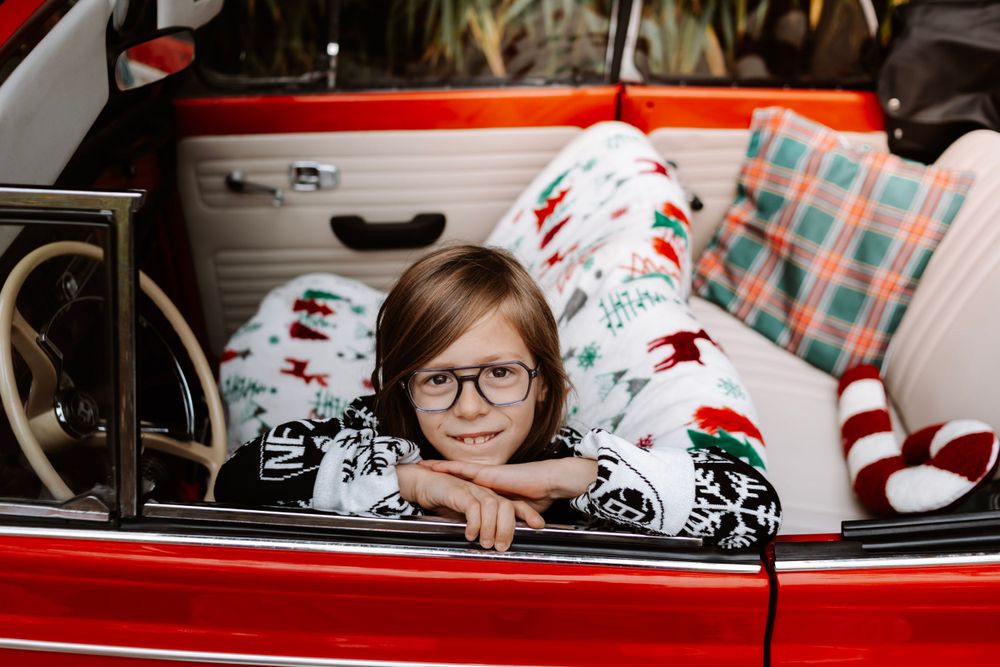 Mini-session photo de Noël 2024 avec une coccinelle VW rouge décorée pour les fêtes, créant une ambiance festive et chaleureuse.