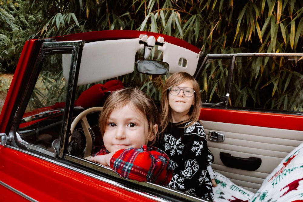 Mini-session photo de Noël 2024 avec une coccinelle VW rouge décorée pour les fêtes, créant une ambiance festive et chaleureuse.