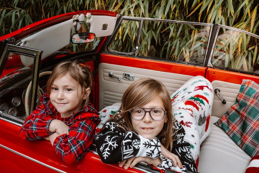 Mini-session photo de Noël 2024 avec une coccinelle VW rouge décorée pour les fêtes, créant une ambiance festive et chaleureuse.