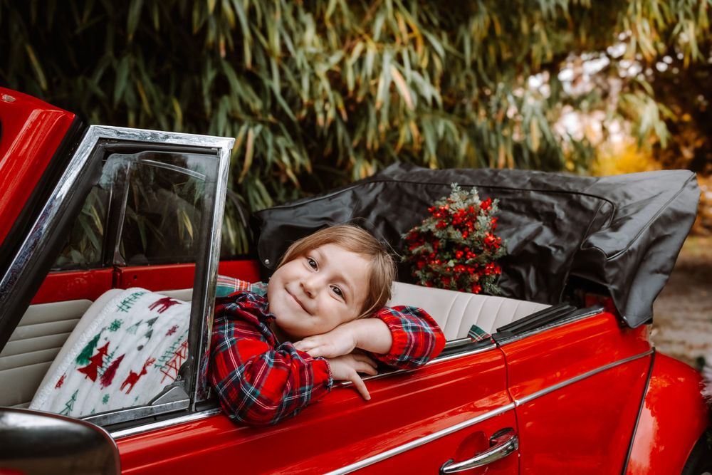 Mini-session photo de Noël 2024 avec une coccinelle VW rouge décorée pour les fêtes, créant une ambiance festive et chaleureuse.