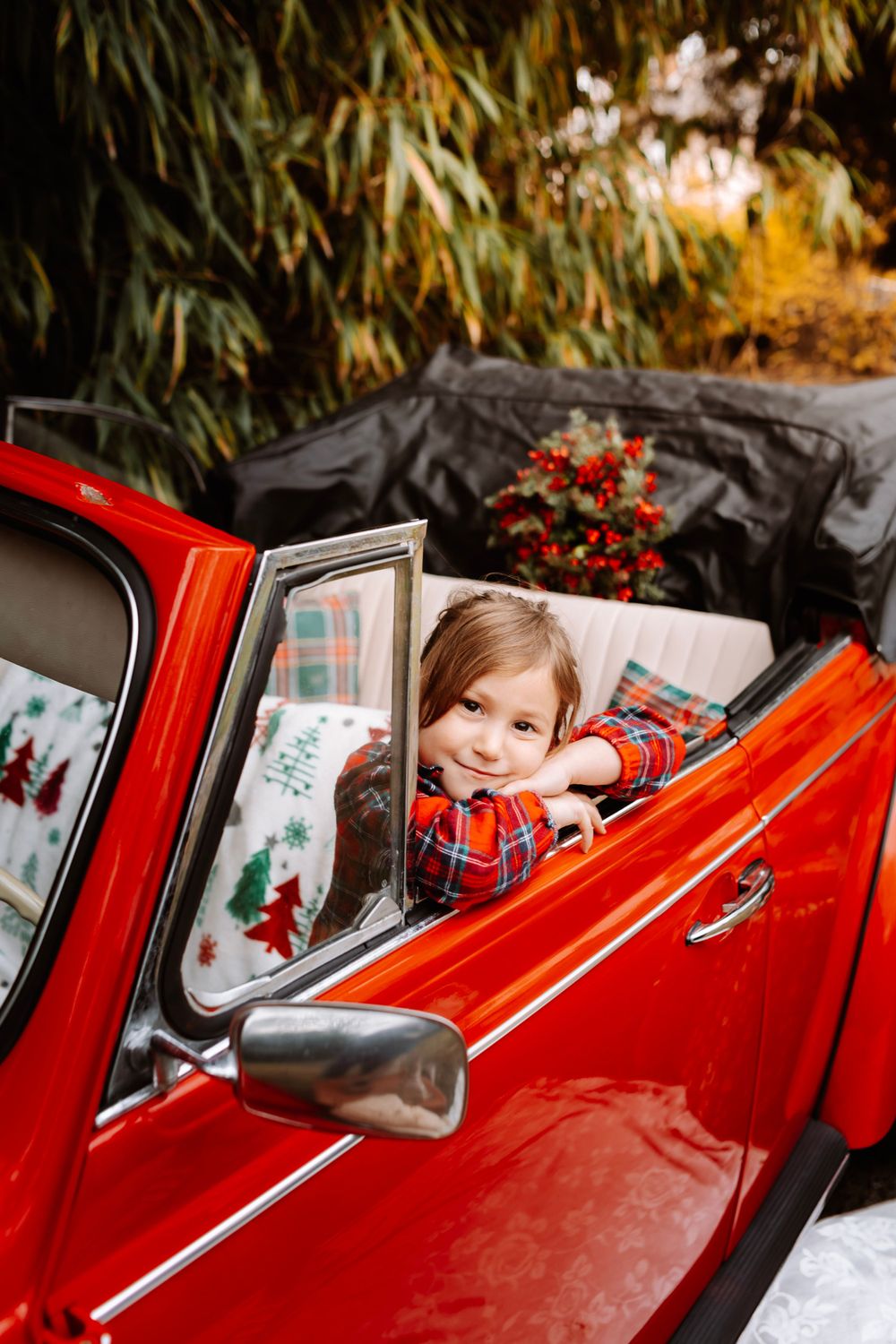 Mini-session photo de Noël 2024 avec une coccinelle VW rouge décorée pour les fêtes, créant une ambiance festive et chaleureuse.