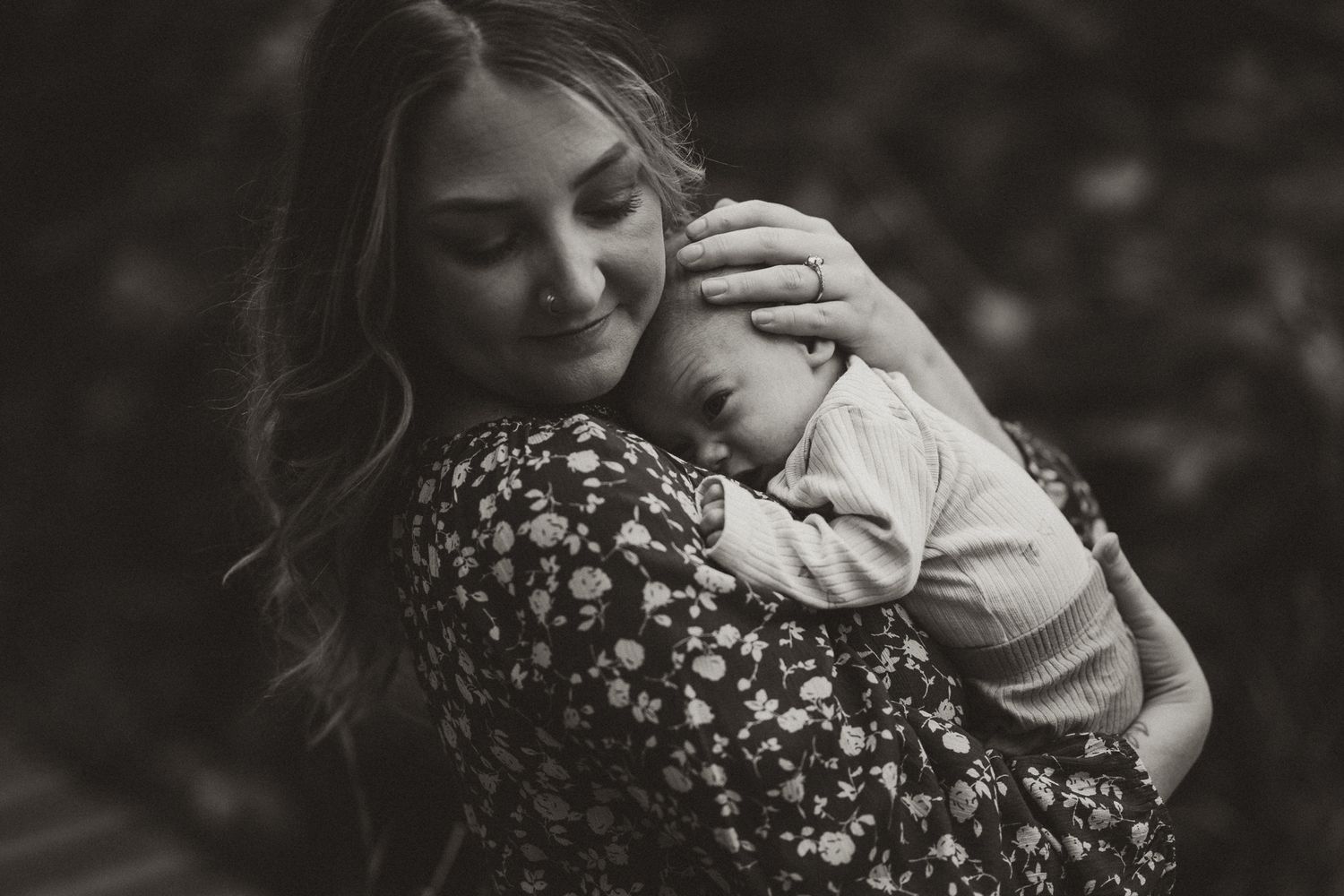 Black and white portrait of tender moment between parent and baby.