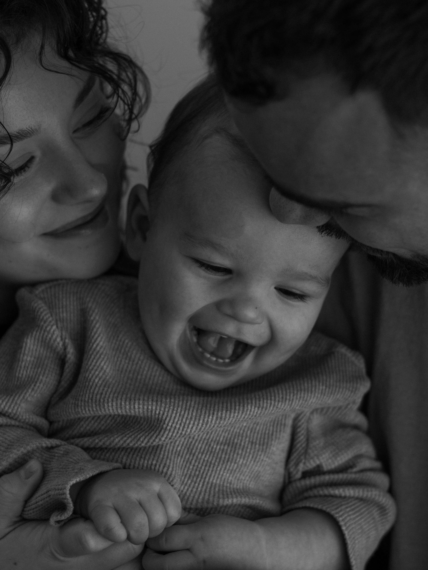 Black and white photograph of a joyful family moment showing pure happiness and laughter.