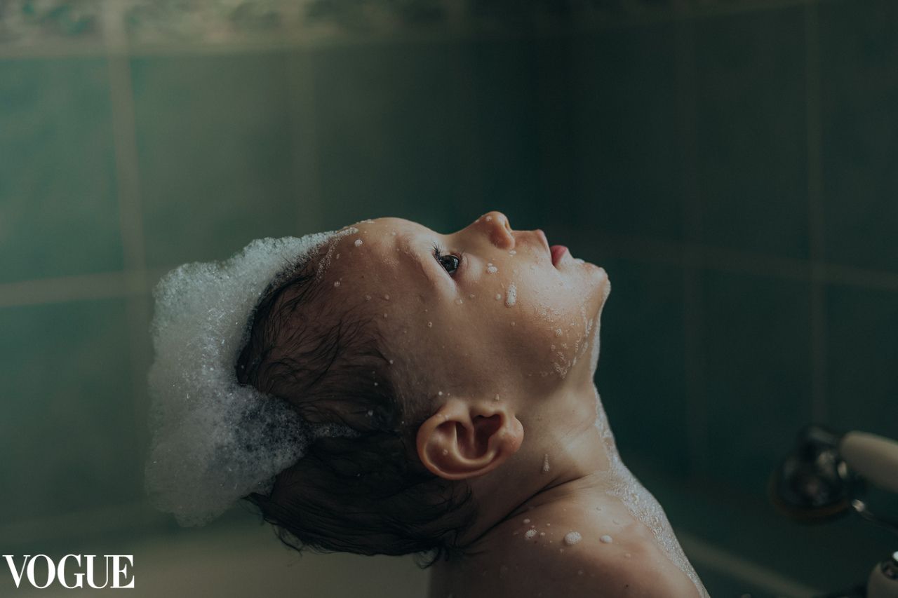 vogue , child looking up, bath bubbles on hair,grainy, natural light