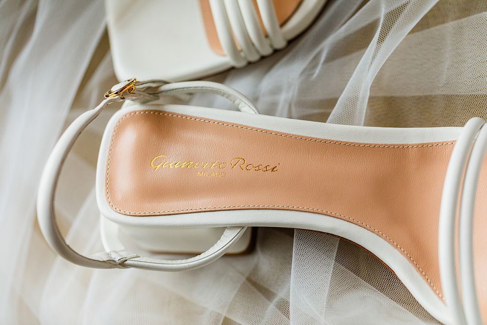 Elegant tan and white bridal shoe detail against soft tulle fabric.