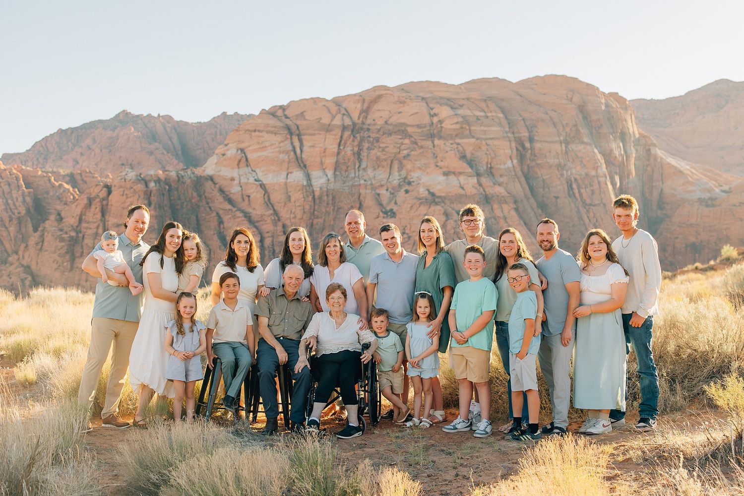 Large family group portrait with mountain backdrop in Snow Canyon State Park.