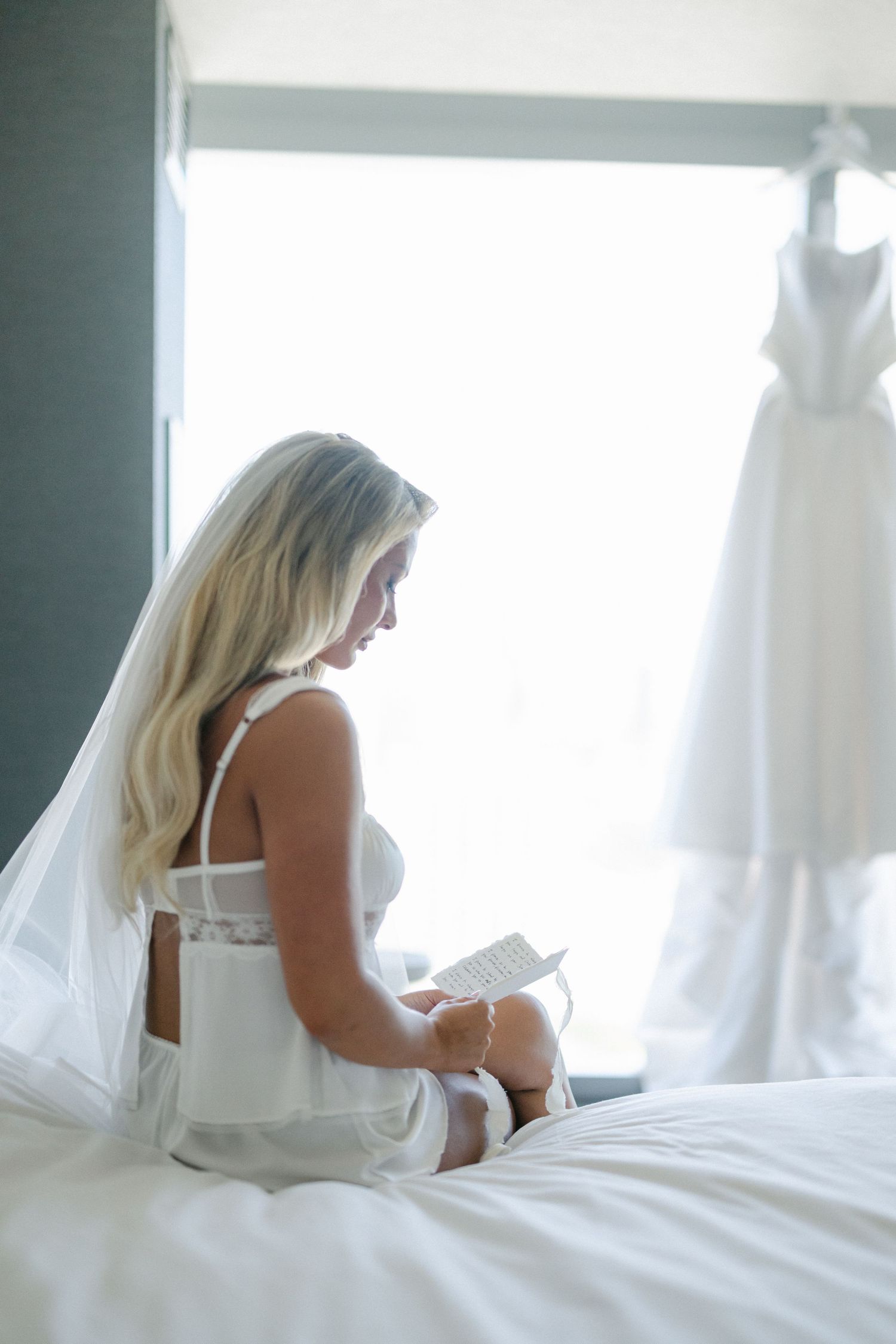 A series of dreamy boudoir photos showing a figure in white sitting on a bed reading a book.