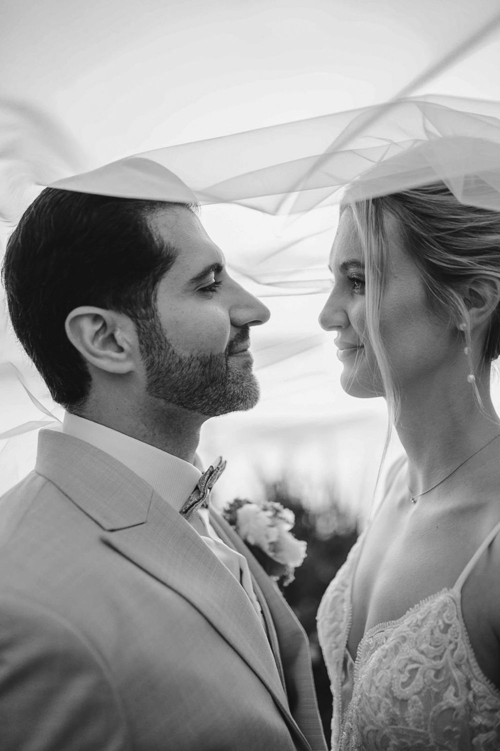 Black and white wedding photo sequence showing intimate moments between newlyweds under a white veil.