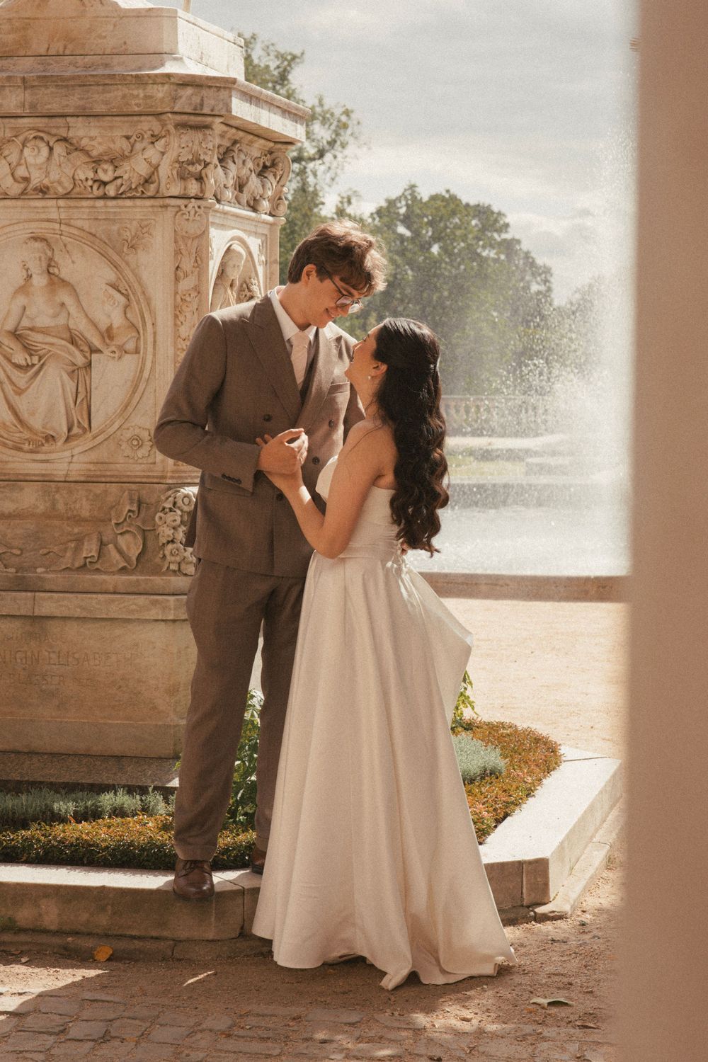 Romantic wedding couple embraces in a series of tender moments against an ornate stone architectural backdrop.