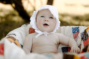 White lace bonnet and quilt details captured in warm outdoor lighting.