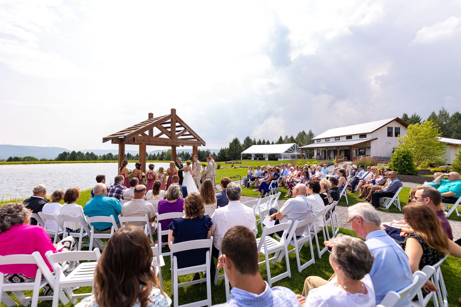 A church wedding ceremony in progress with guests seated in wooden pews and stained glass windows visible in the background.
