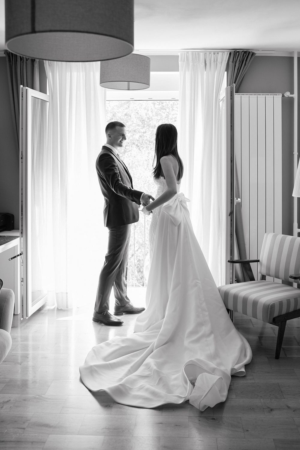 Series of black and white photos capturing intimate wedding dance moments in a sunlit room with white curtains.