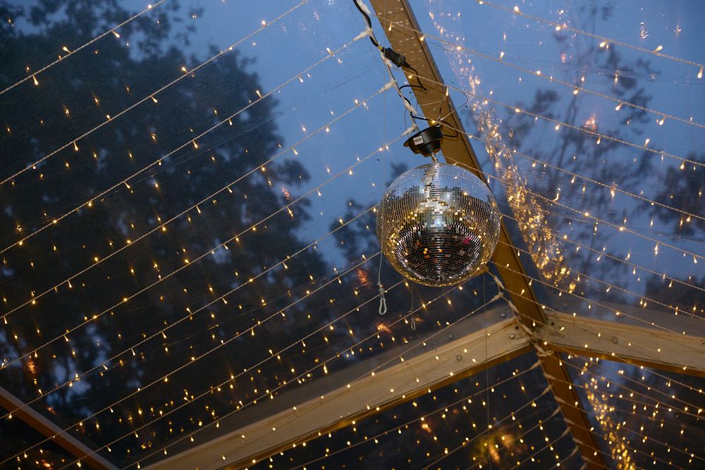 String lights create a magical canopy overhead at an outdoor evening event.