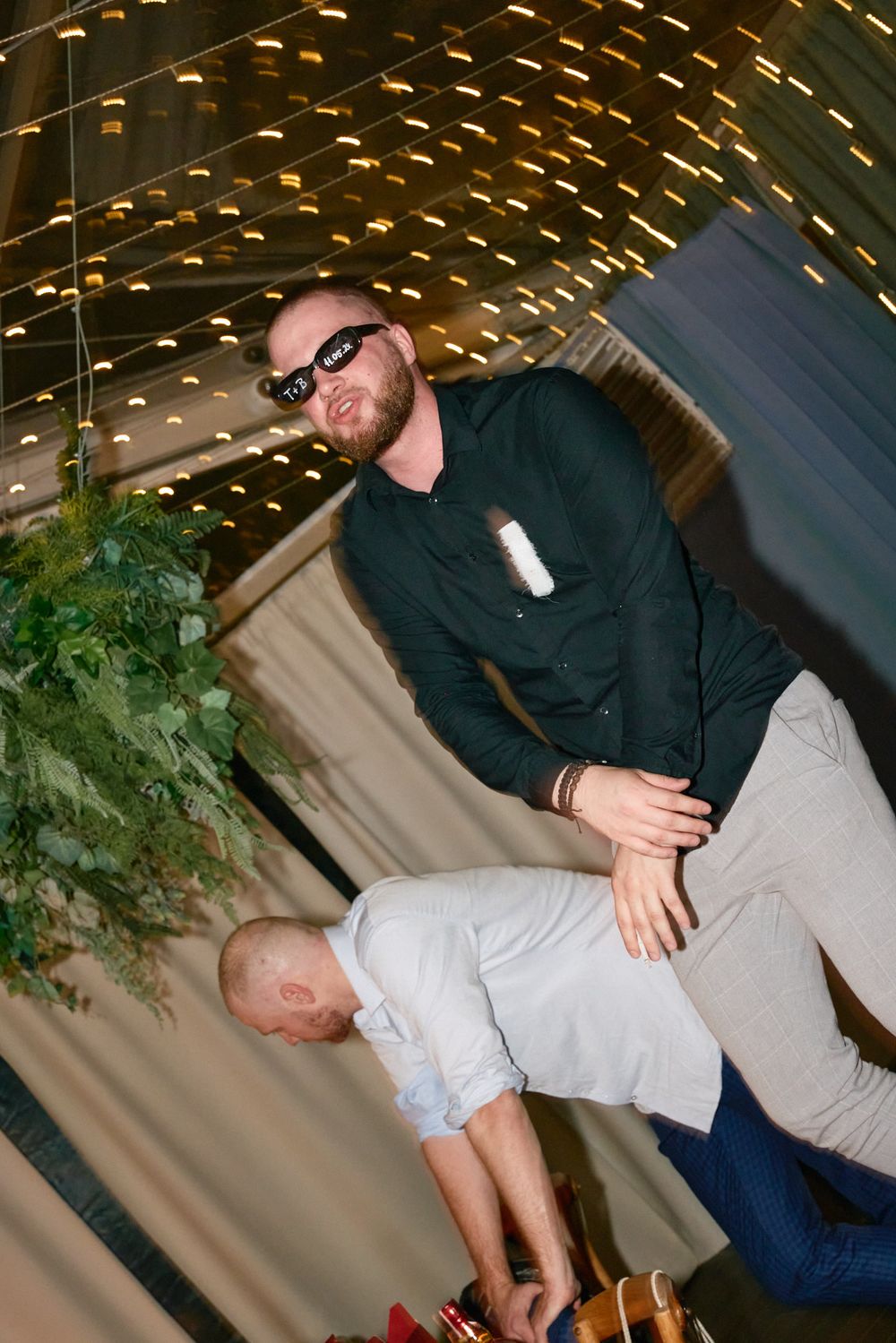 A sequence of dance moves at a wedding reception with string lights overhead.