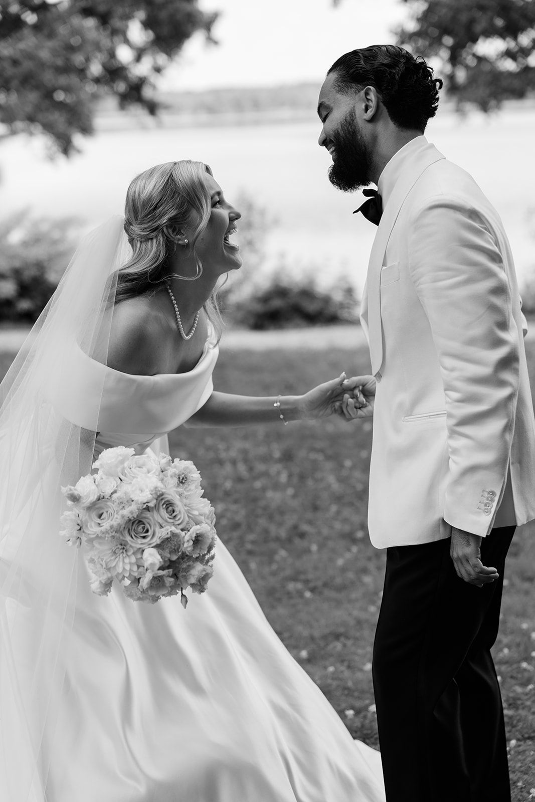 A bride and groom share a romantic dance moment outdoors in black and white photography.