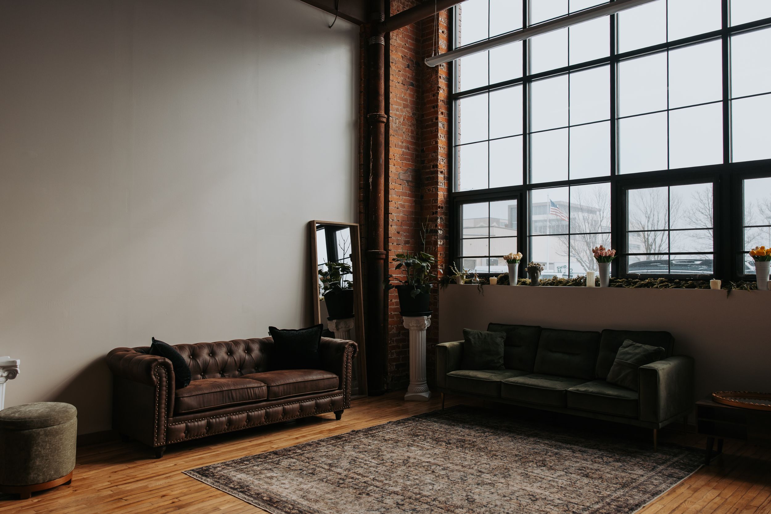 Modern industrial studio space with exposed brick walls and large windows.