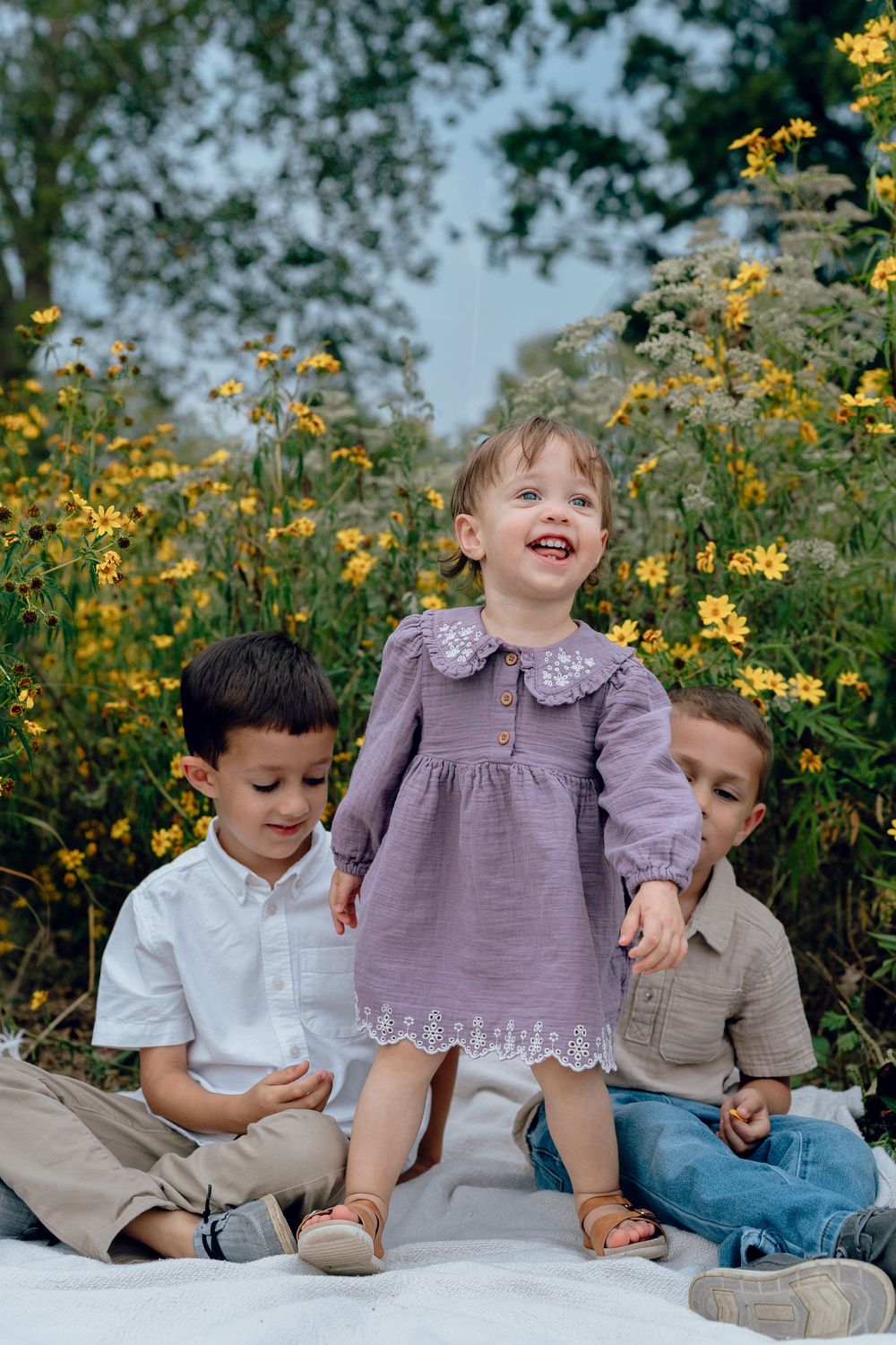 Candid playful moment captured outdoors with yellow wildflowers blooming in Akron, Ohio Cascade Valley Metro Park for Family Photo Session