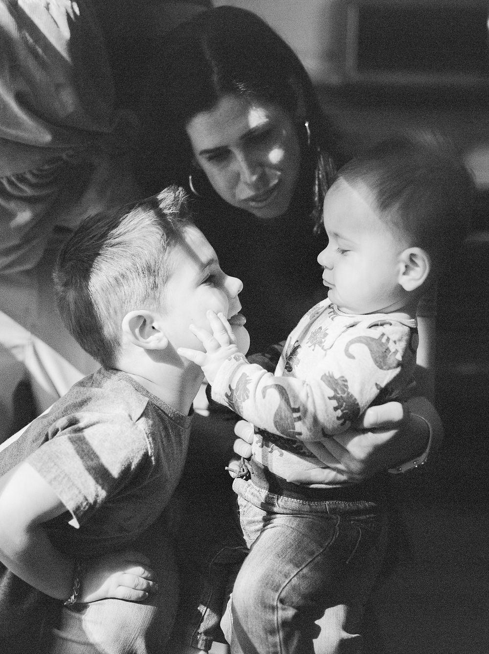A black and white photo series shows a tender moment between two people in an intimate embrace.