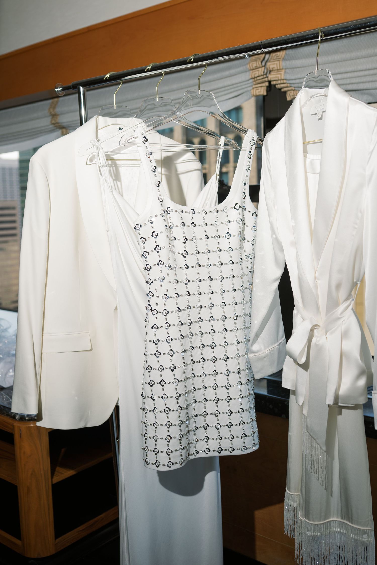 White vintage clothing and dresses hanging on display racks showing delicate lace and eyelet details.