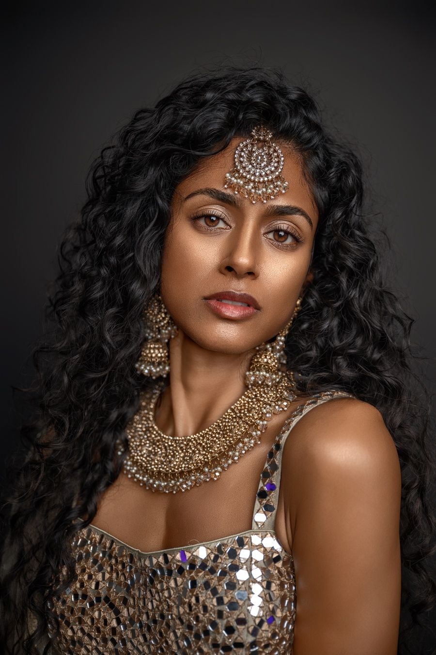 Glamorous portrait series featuring ornate gold jewelry and sequined attire against dark background.