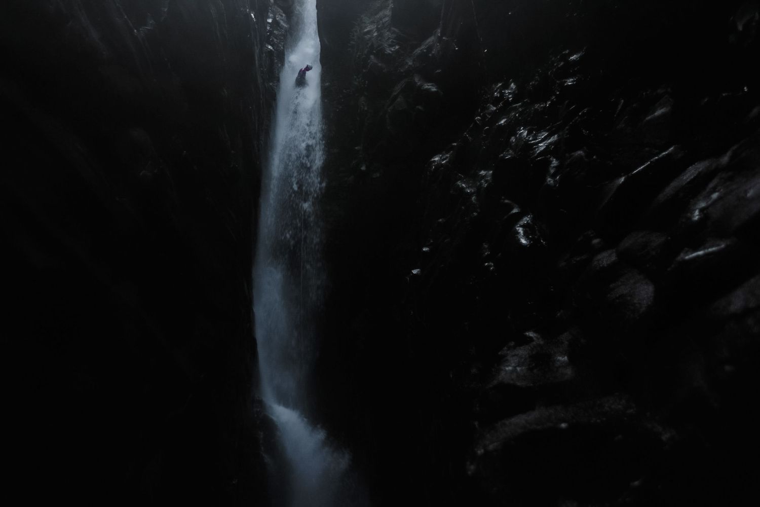 Flowing waterfall cascades over mossy rocks creating a misty ethereal effect in nature.