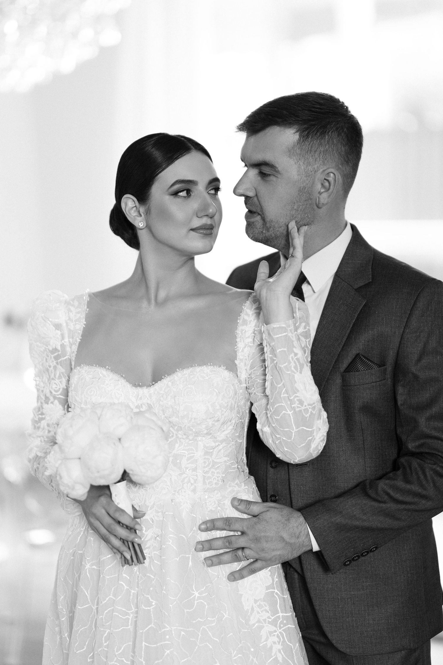 Black and white wedding photo series showing tender moments between newlyweds in elegant attire.