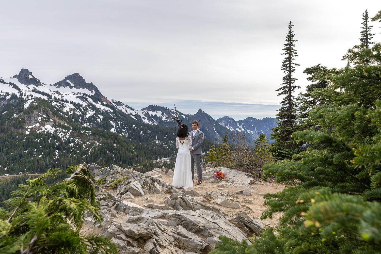Bride and groom eloping on rocky mountain summit  in Mount Rainier National Park.