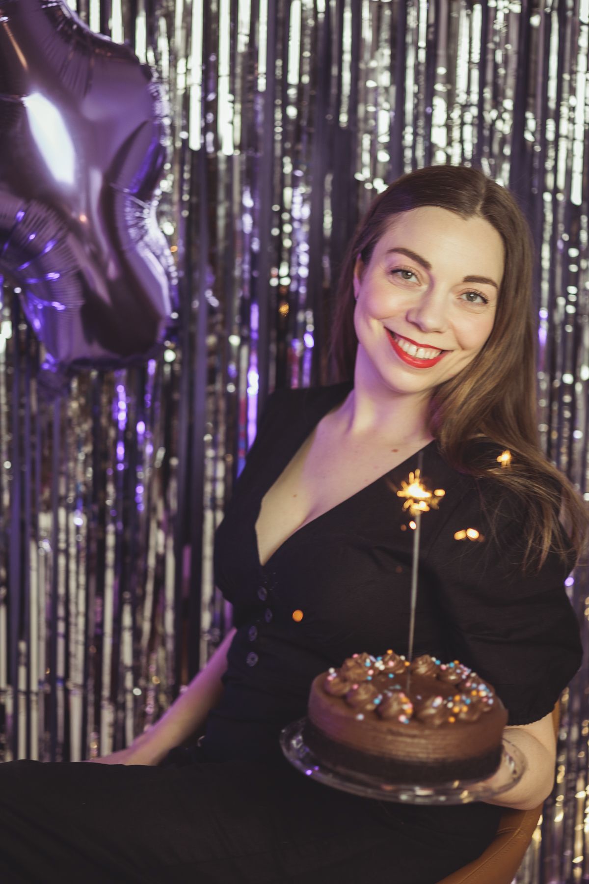 A girl celebrating a milestone with a cake and sparkler